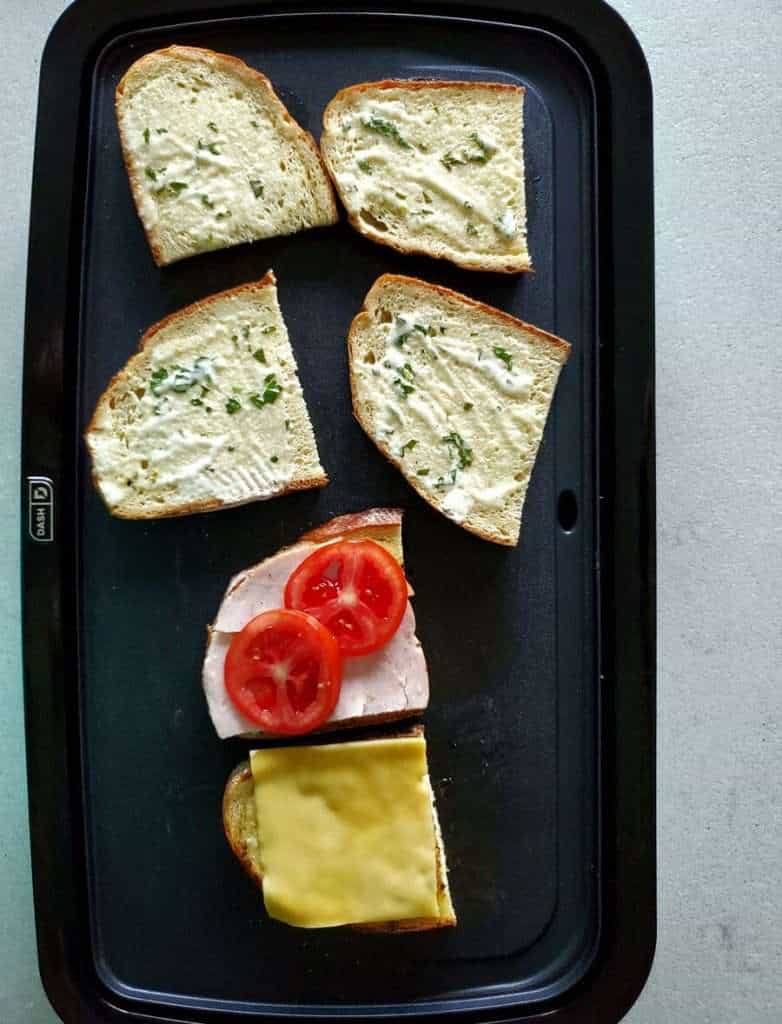 Sandwich ingredients on a griddle.