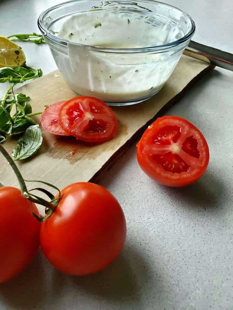 Sliced tomatoes with mayo spread.