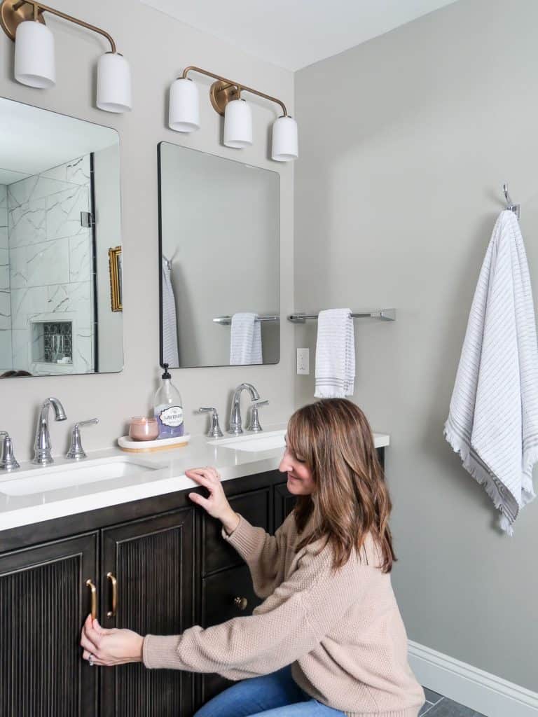 Woman in front of a timeless bathroom vanity.