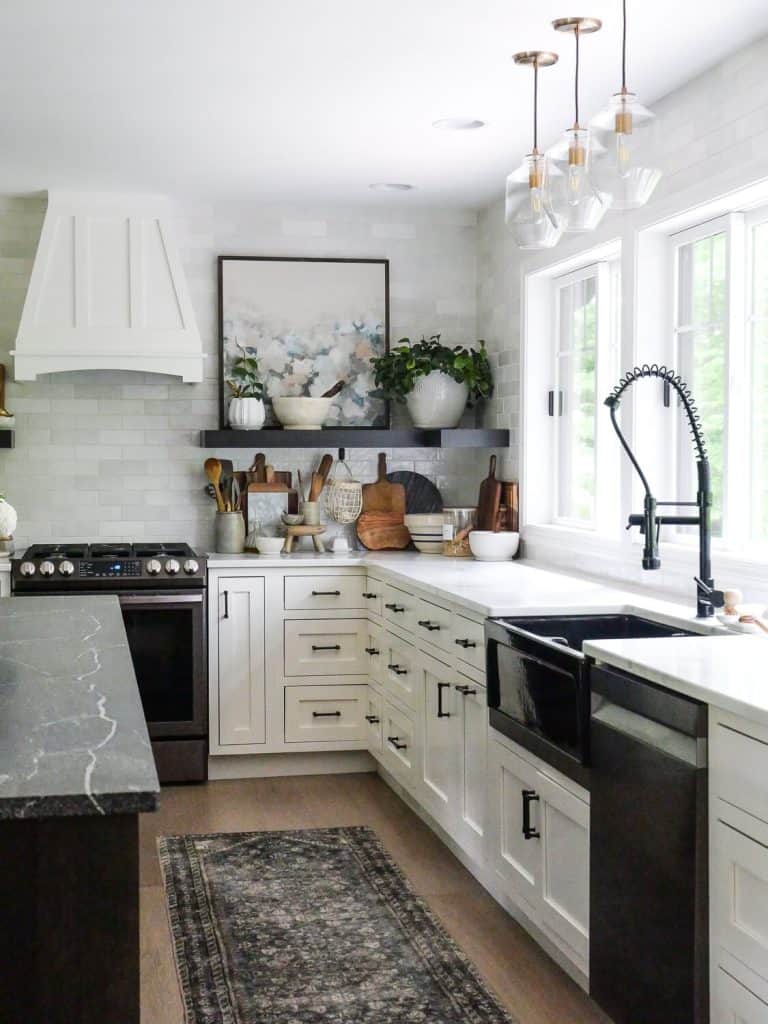 Kitchen with black sink and white countertops.