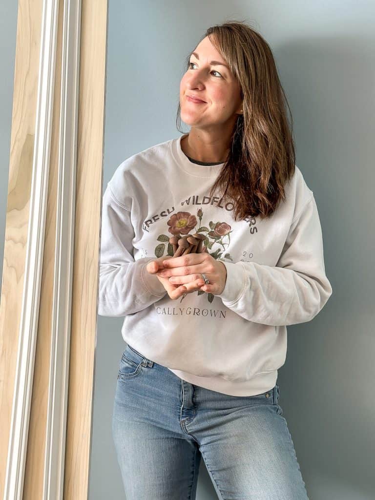 Woman standing by wood trim.