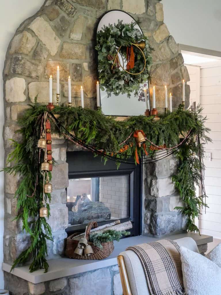 Stone fireplace decorated with christmas decor essentials.