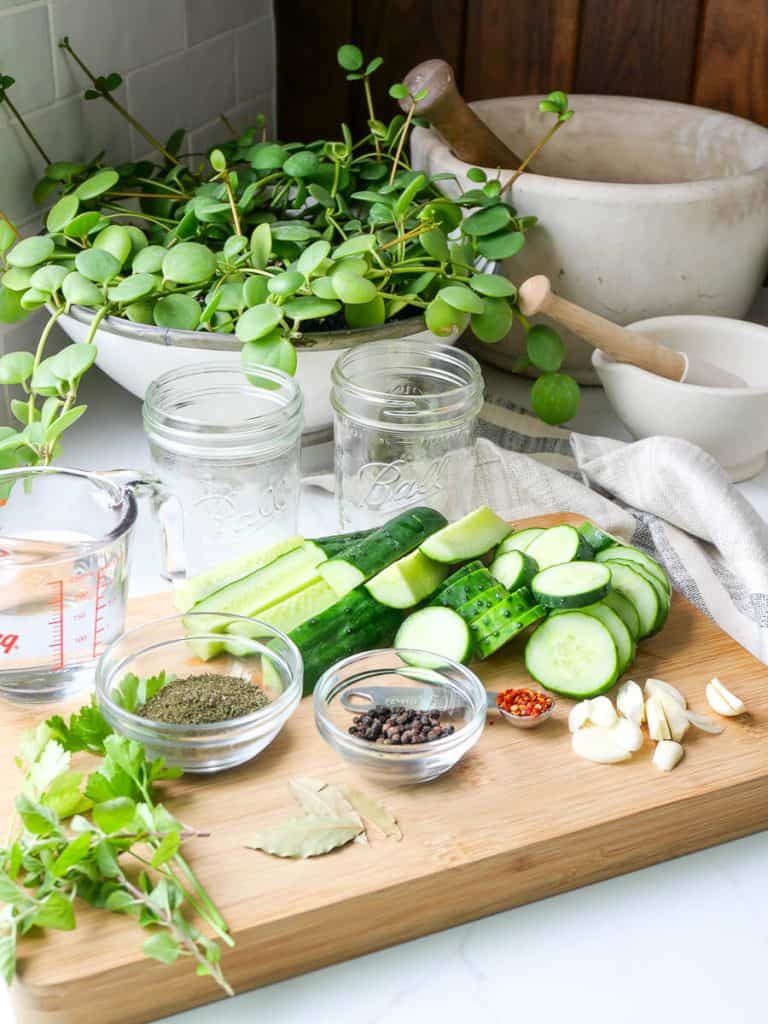 Cucumbers sliced on a cutting board with spices.