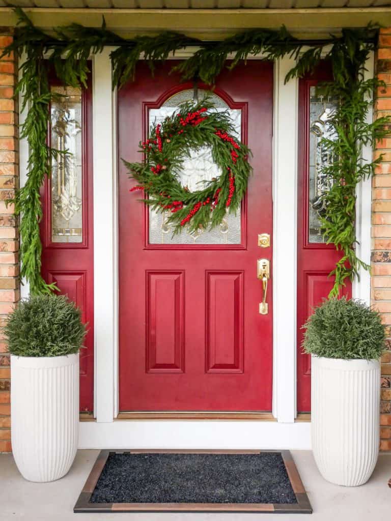 Cedar faux spheres by a red front door.