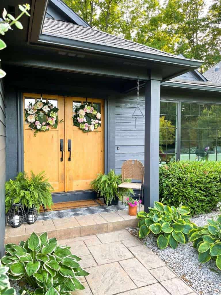 Low maintenance flower beds by a front door.