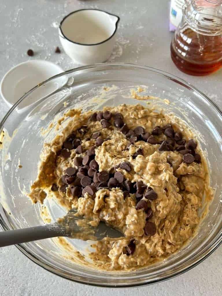 Adding chocolate chips to dough mixture.