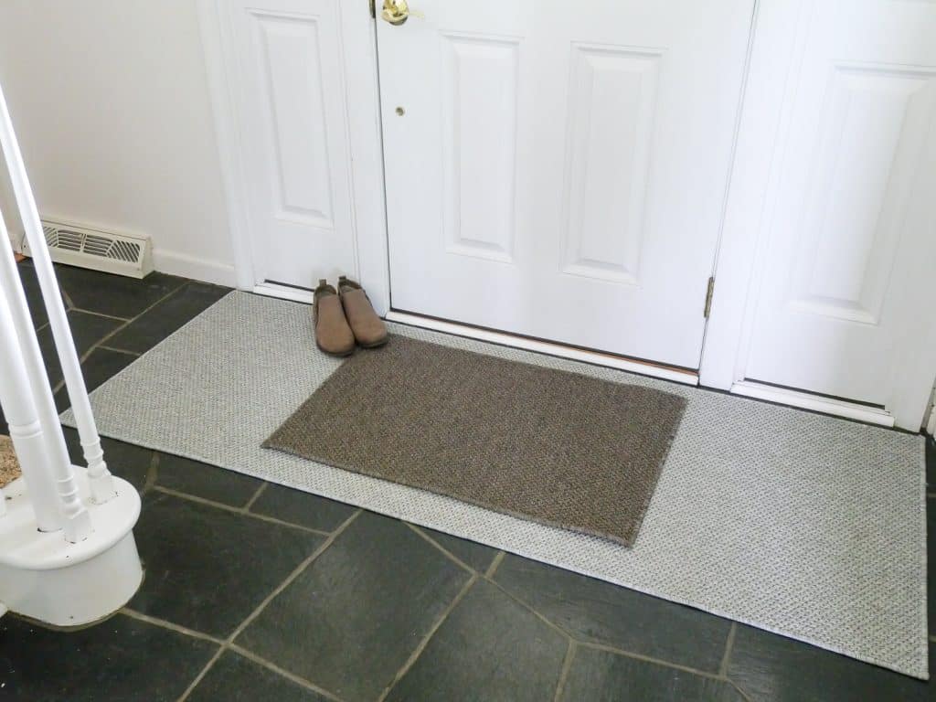 Two entry doormats at a front door.