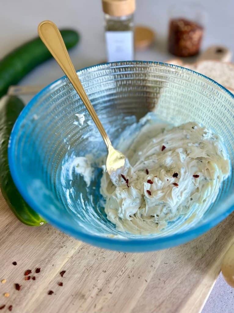 Adding red pepper to cream cheese mixture.