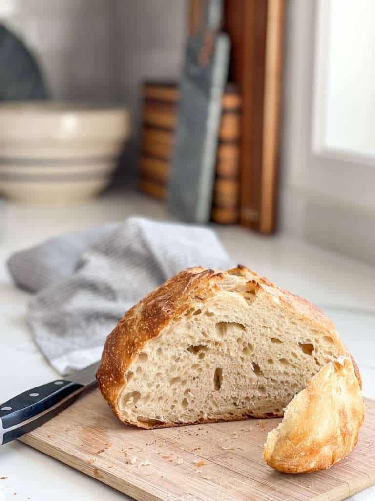 Small sourdough loaf sliced on a cutting board.