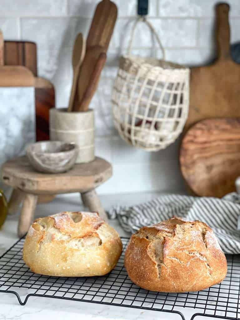 Two small sourdough loaf breads on a countertop.