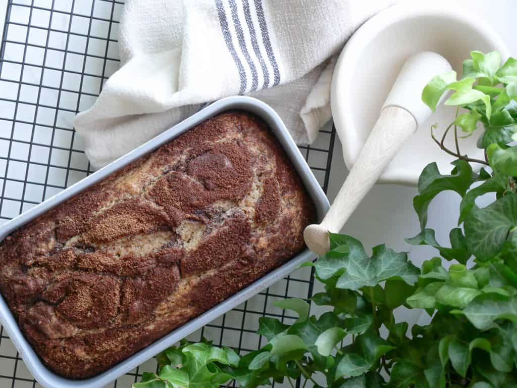 Loaf of bread cooling in a pan.